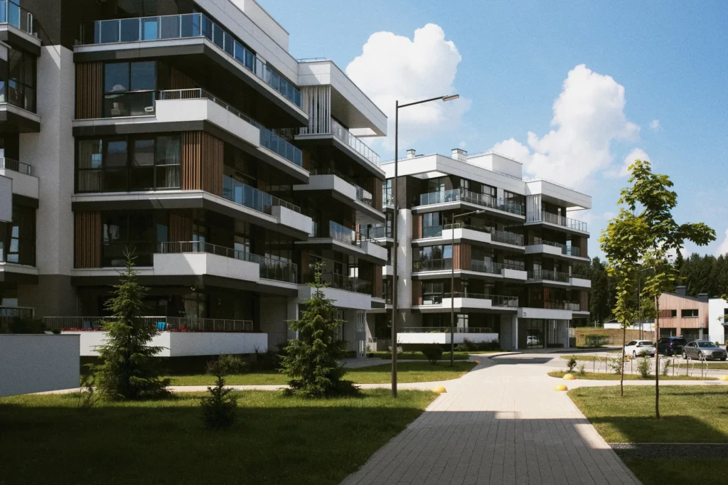 Modern residential apartment buildings with glass balconies and landscaped grounds.