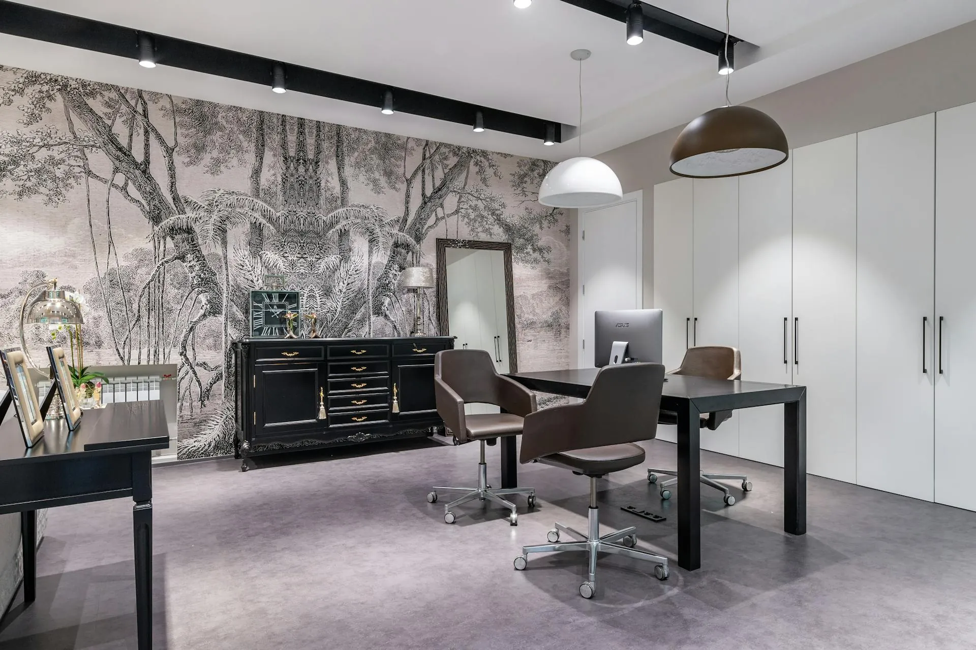 Modern office interior with black desk, brown swivel chairs, white cabinets, pendant lamps and a tree mural wall